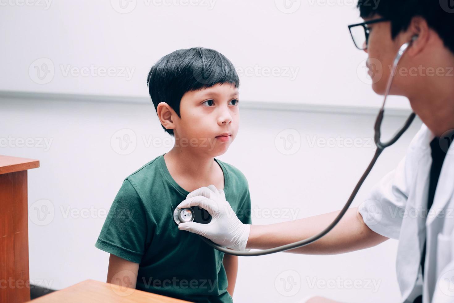 Male doctor hold stethoscope examining child boy patient photo