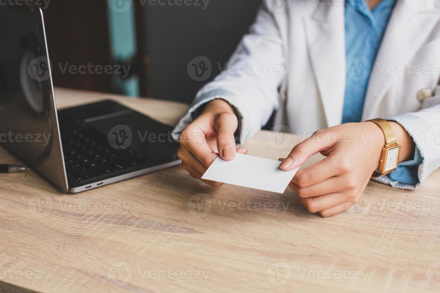 Business woman holding and giving white business card or blank card name in hands. Template for your design. Business card mock up photo