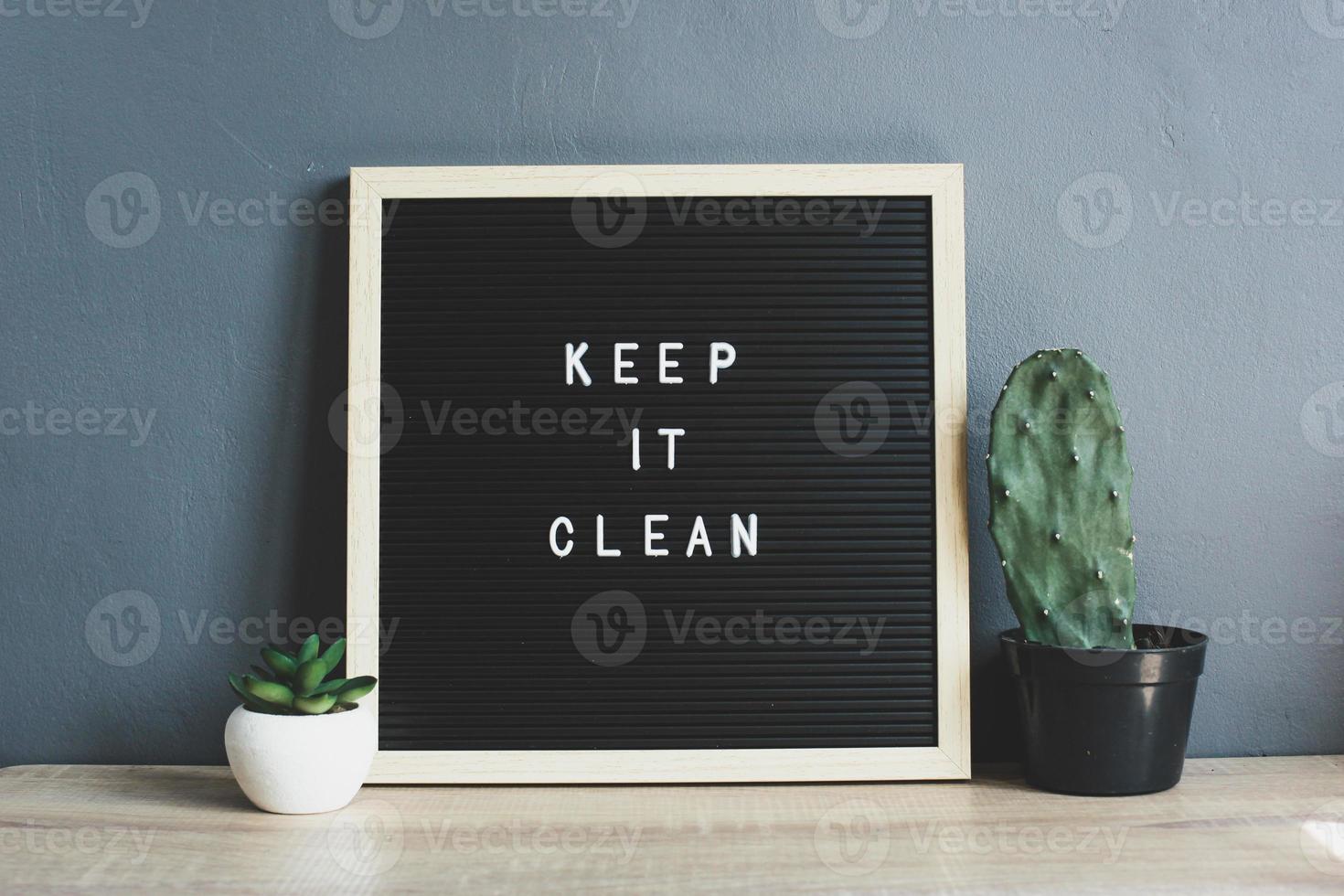 KEEP IT CLEAN quote on blackboard with cactus and succulent on wooden table photo