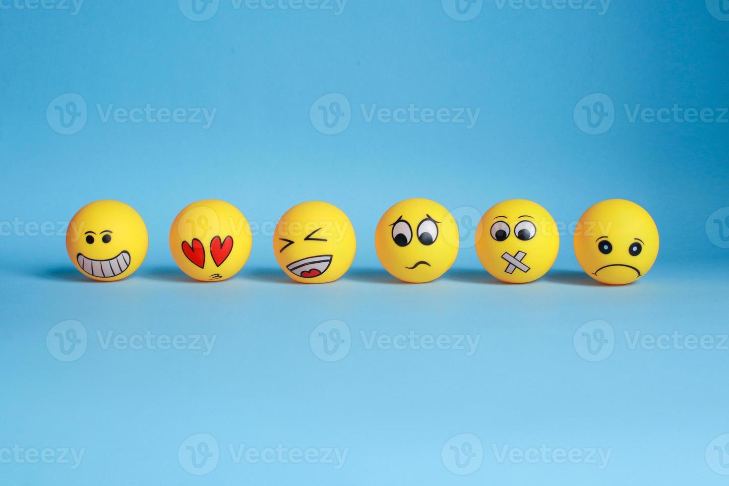 Various hand painted yellow emoticon isolated on blue background photo