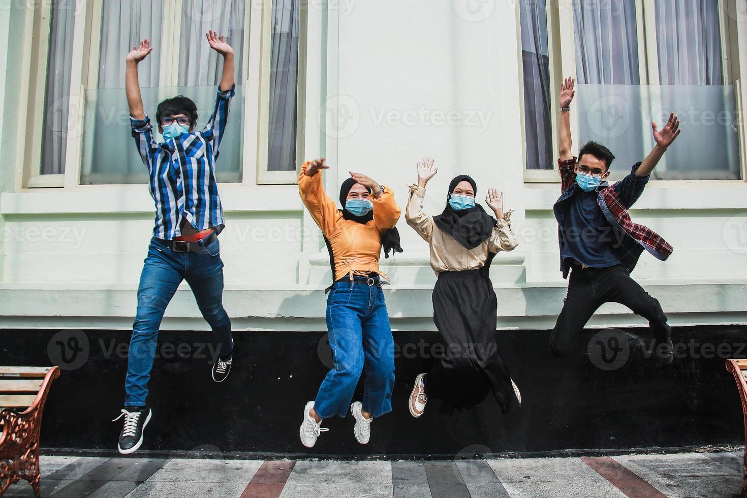 grupo fotográfico borroso de personas con máscara médica para el salto del virus de la corona, juventud, estilo de vida de la ciudad, equipo, concepto de amistad foto