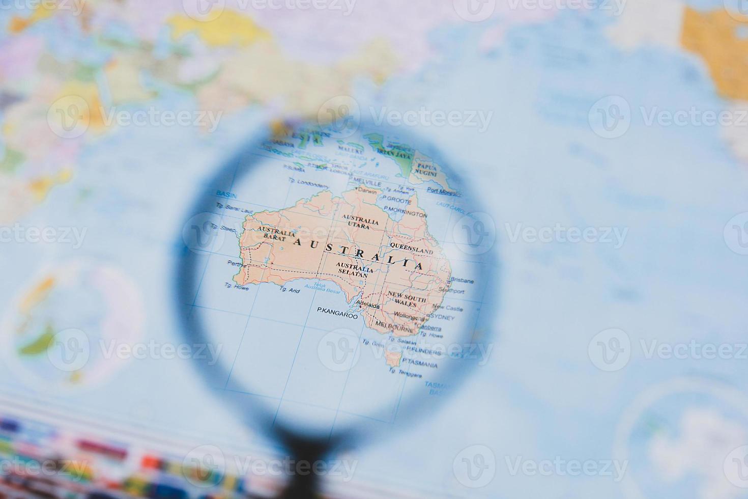 Magnifying glass over a map of Australia, selective focus photo