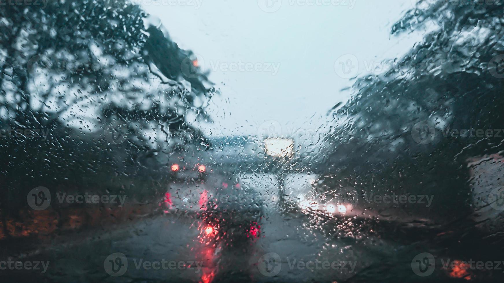 Blurry photo of windshield with heavy rain, view form inside a car driving