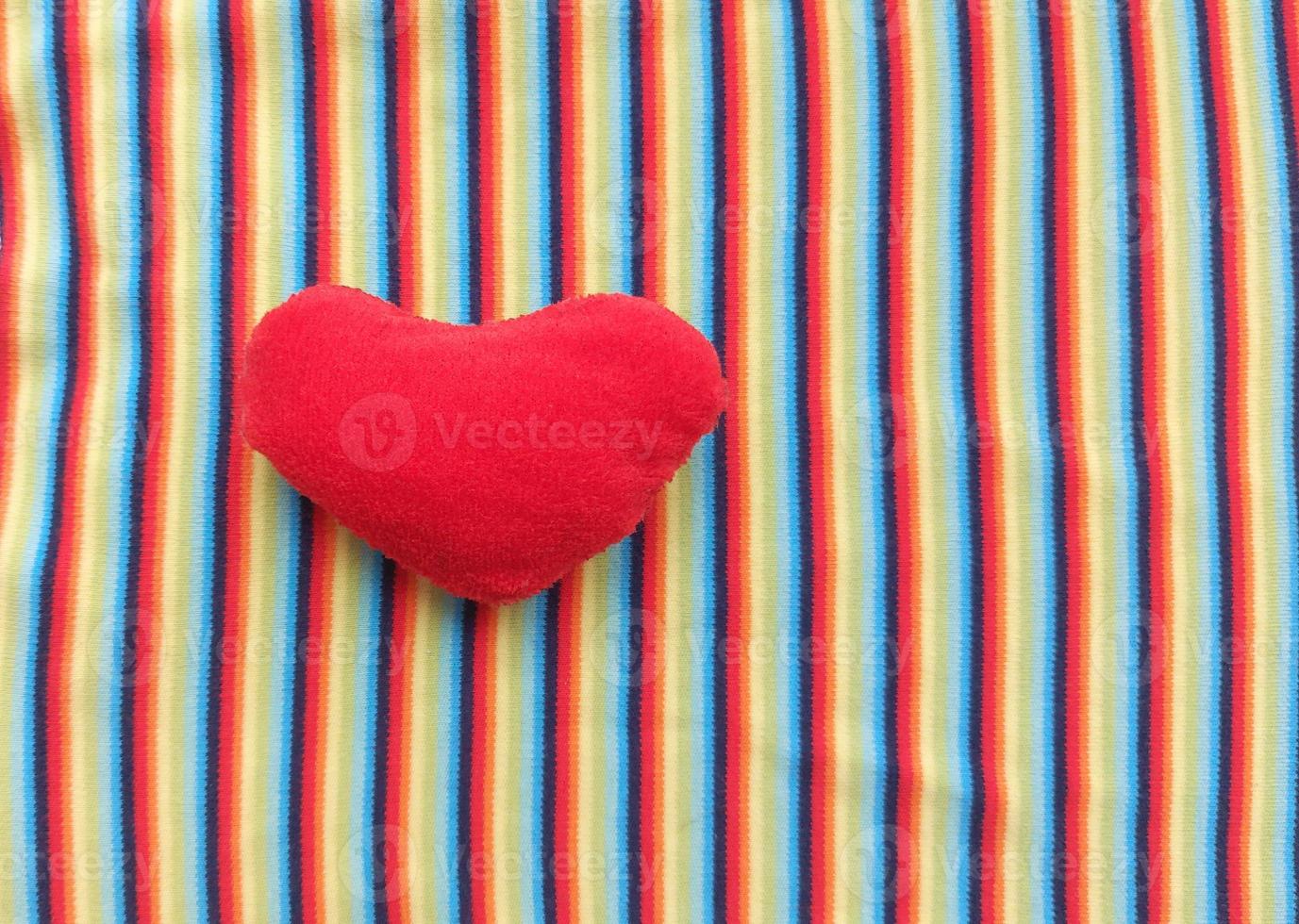 red heart on a background of rainbow fabric. place for text. bright banner, concept. love. copy space. photo