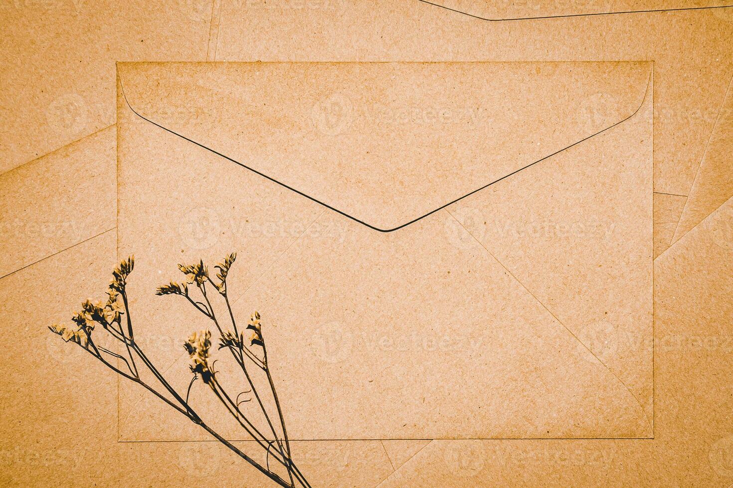 sobre de papel marrón con flor seca de limonium. primer plano del sobre artesanal. minimalismo plano. foto