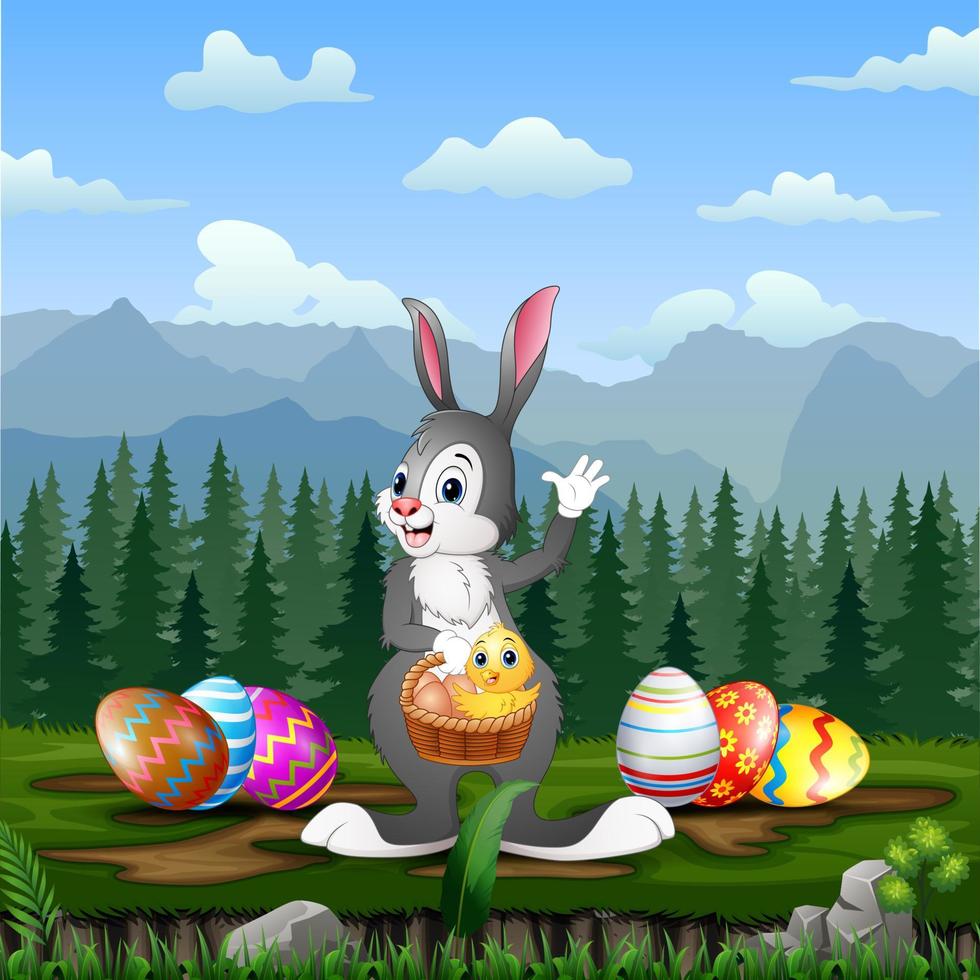 Easter bunny holding a basket of chick with Easter eggs around him vector