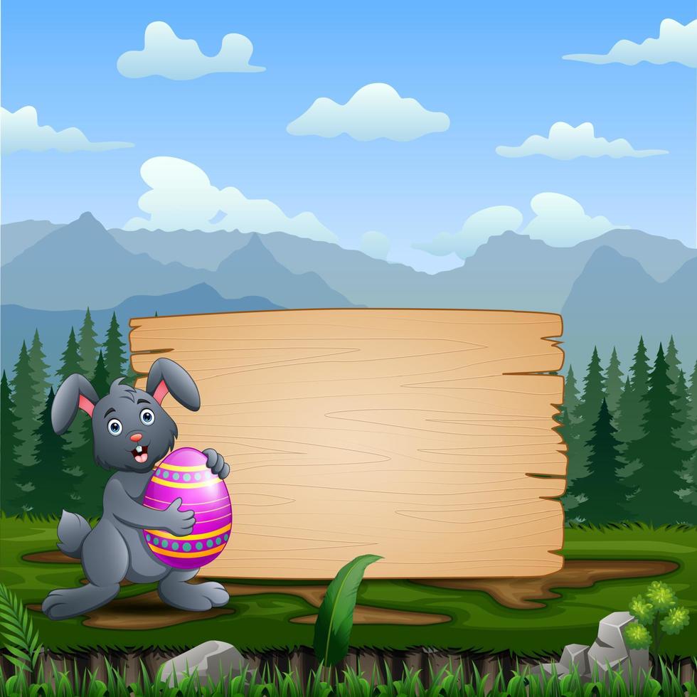 A bunny holding Easter Egg with blank wooden sign vector