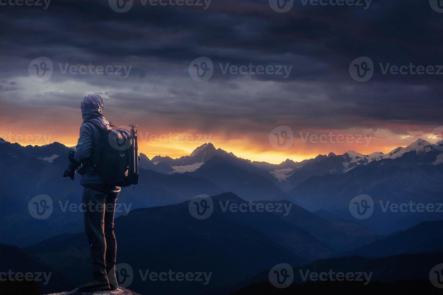 Professional photographer takes photos with big camera on peak of rock