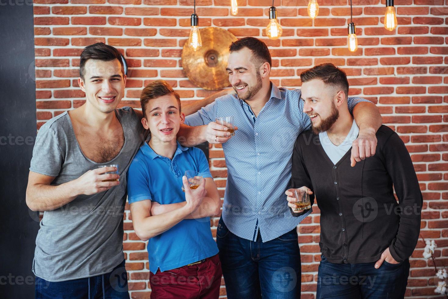 Cheerful old friends communicate with each other  glasses of whiskey in pub. Concept  entertainment and lifestyle photo