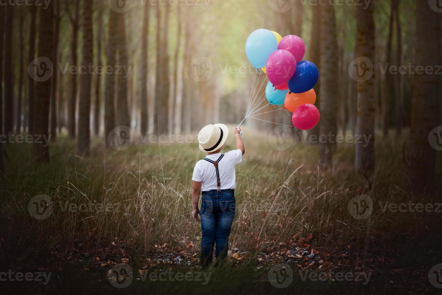 niño con globos en el bosque foto