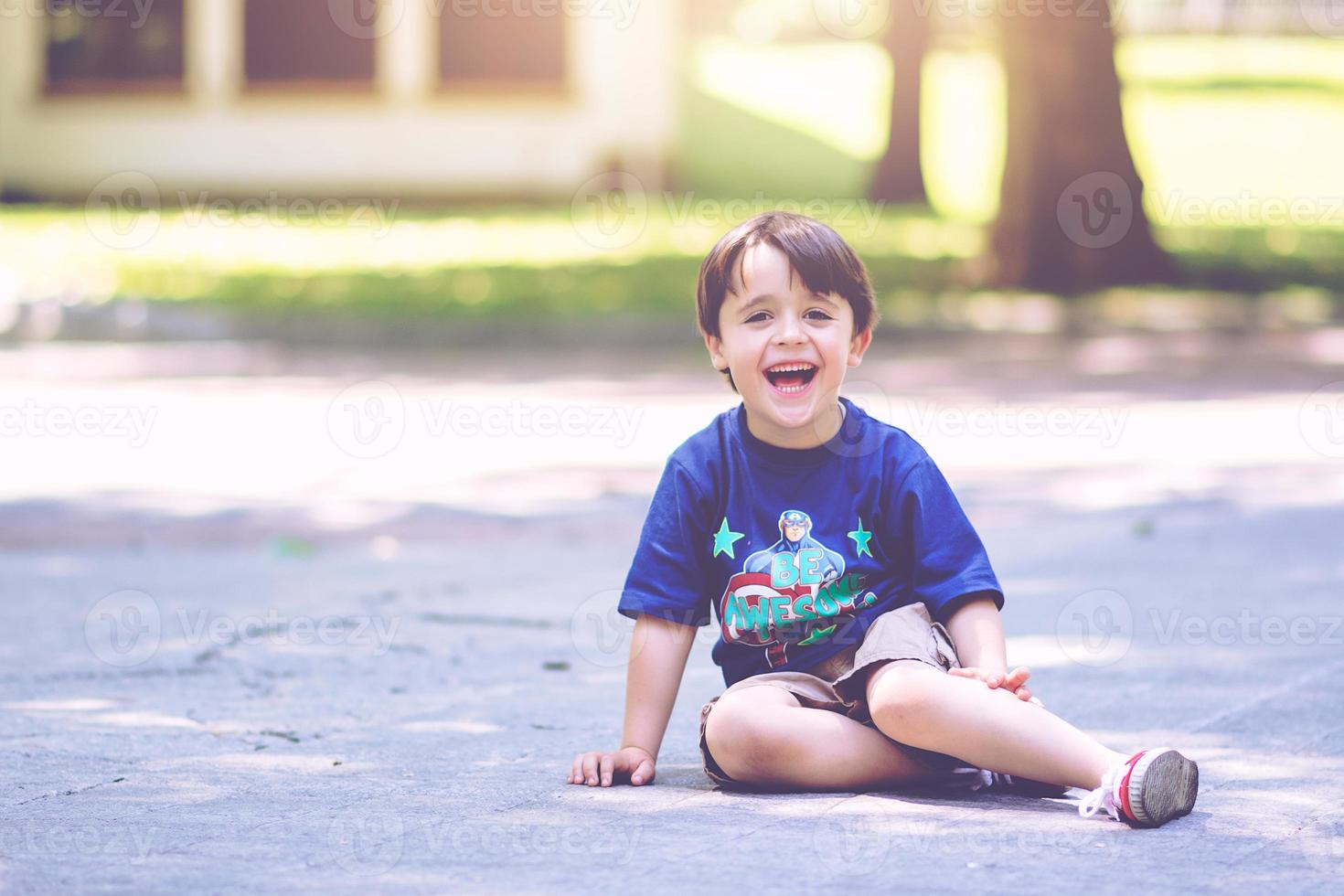 smiling boy sitting in the park photo