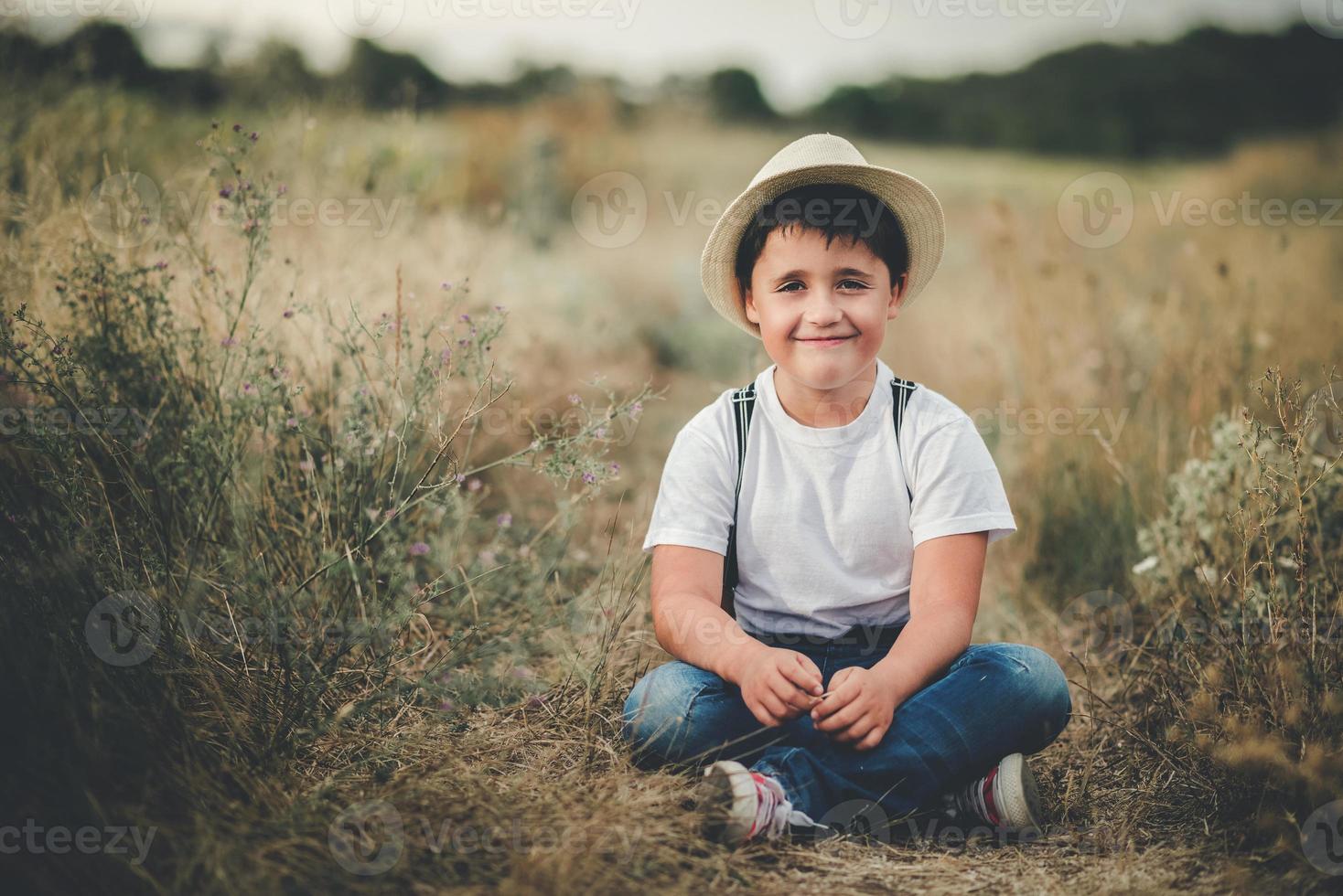 happy child sitting in the field photo