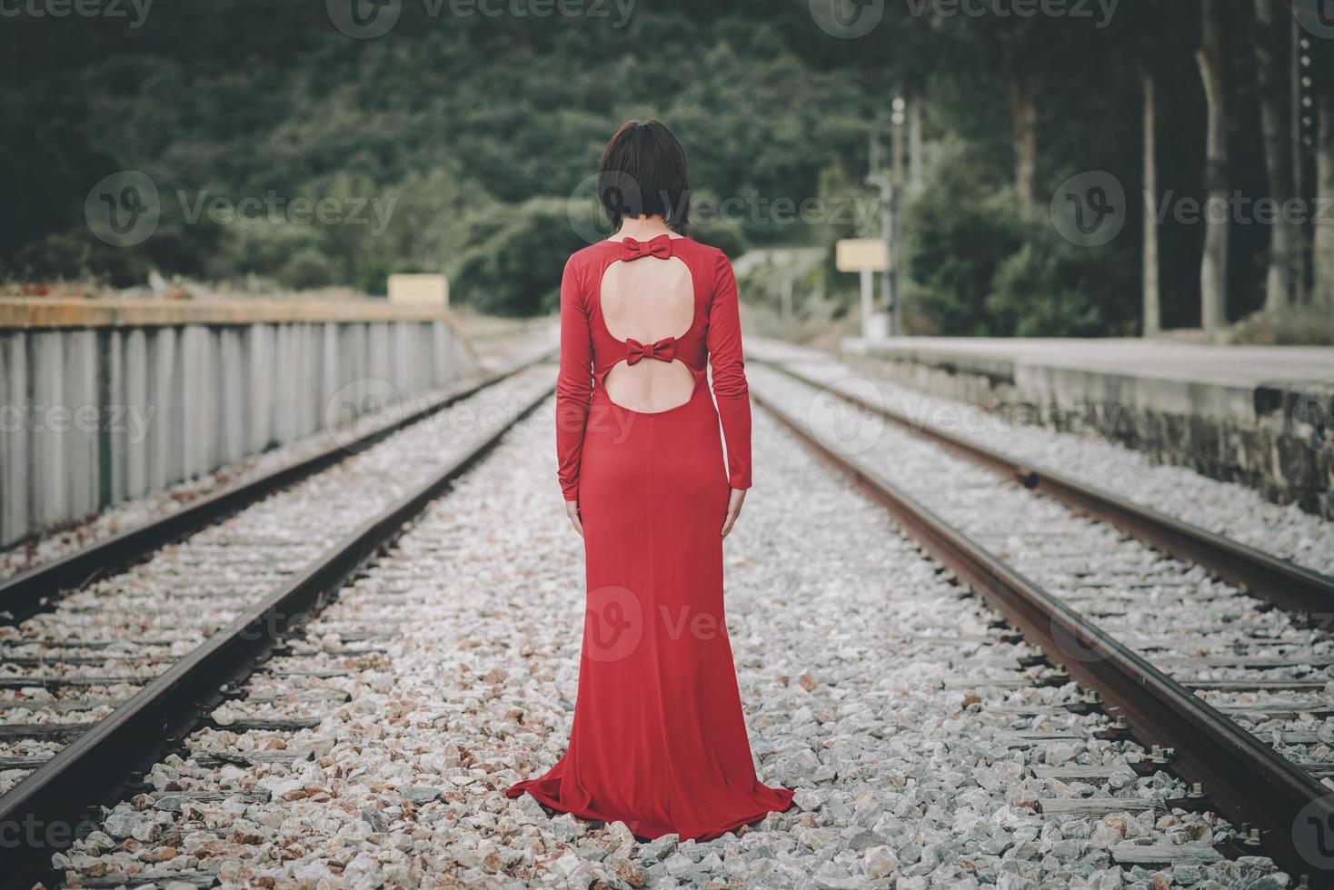 vista posterior de la mujer joven en las vías del tren foto