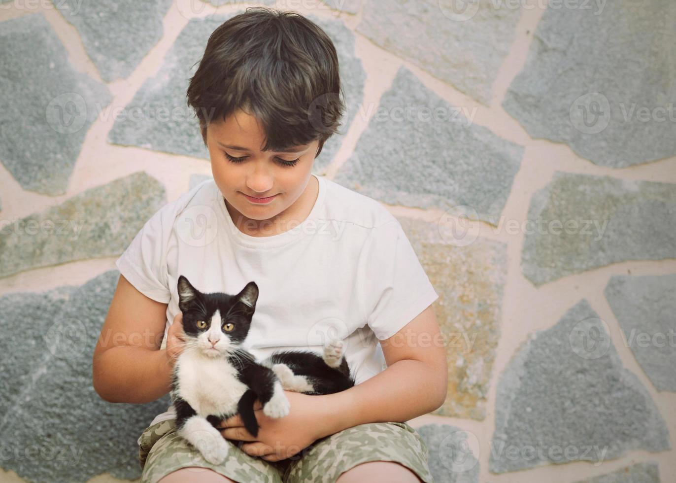 Happy child playing with kitten photo