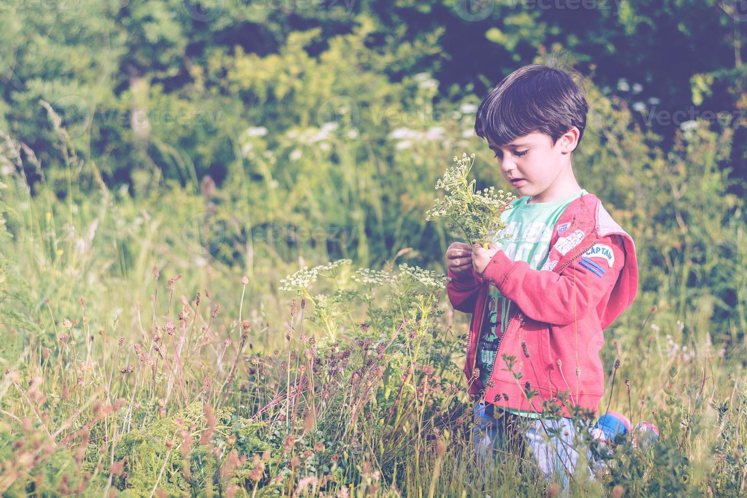 niño triste con una flor foto