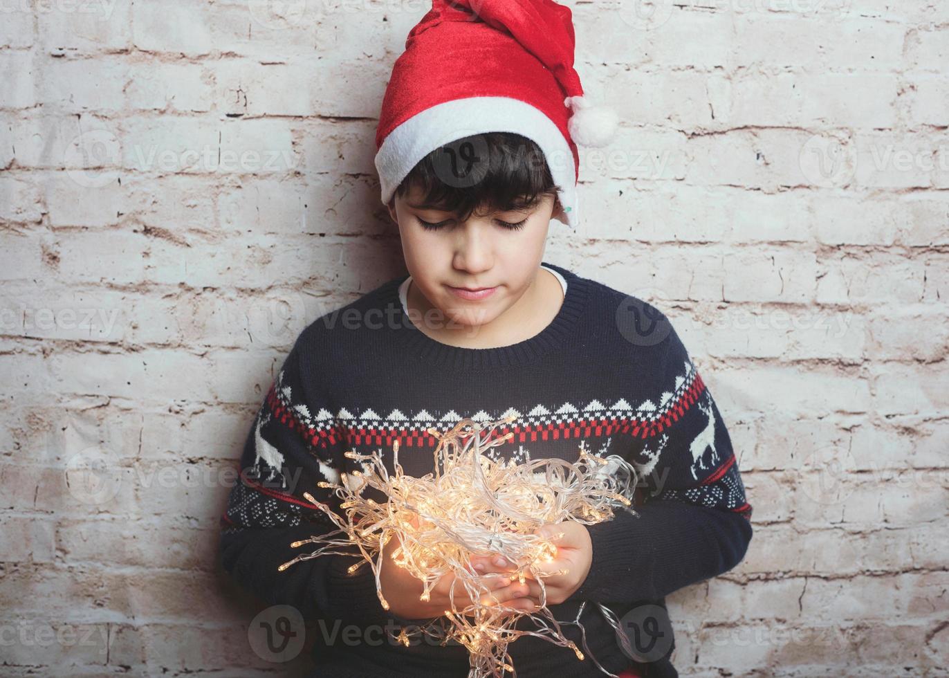 niño con luces de navidad foto