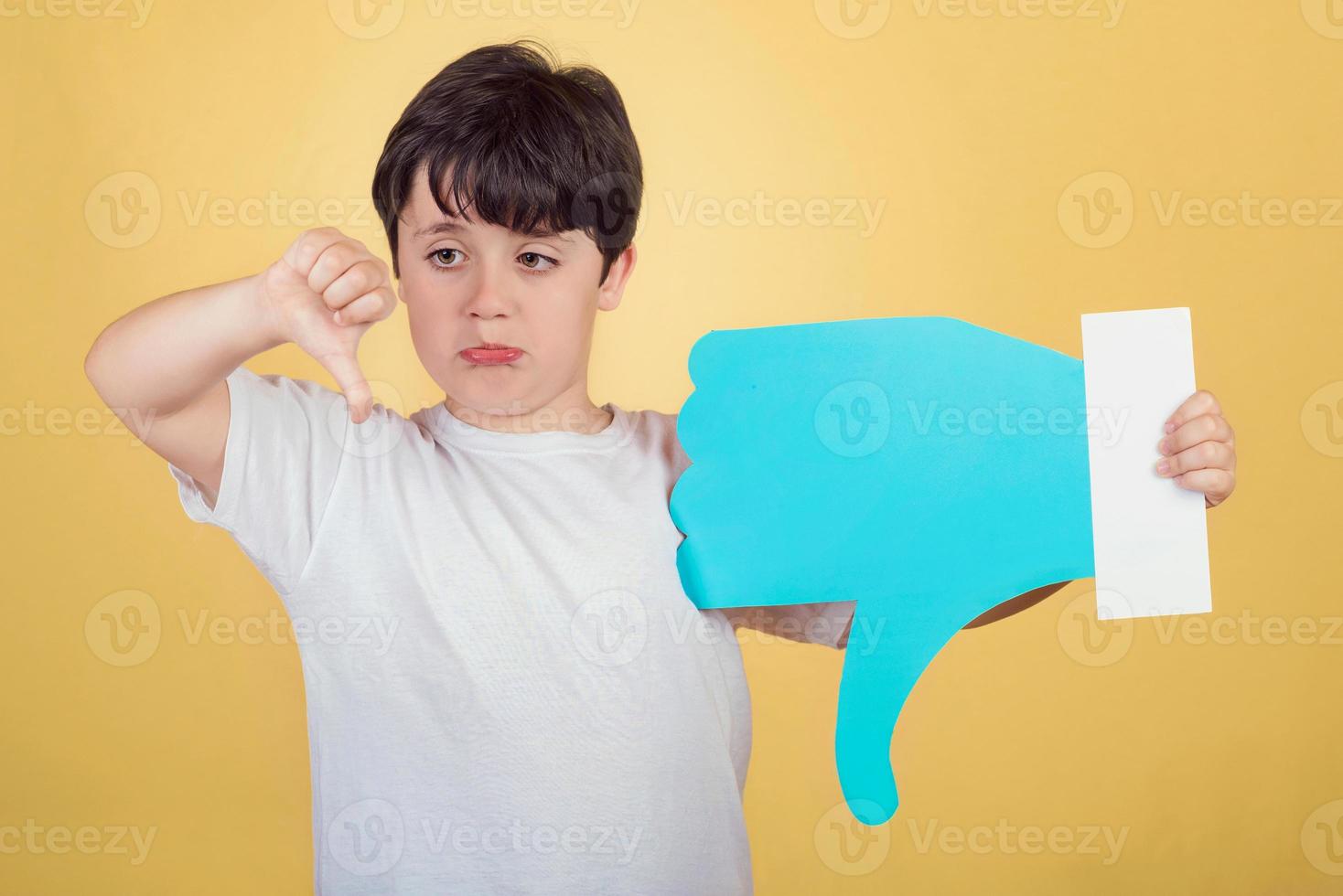 boy holding a dislike icon on yellow background photo
