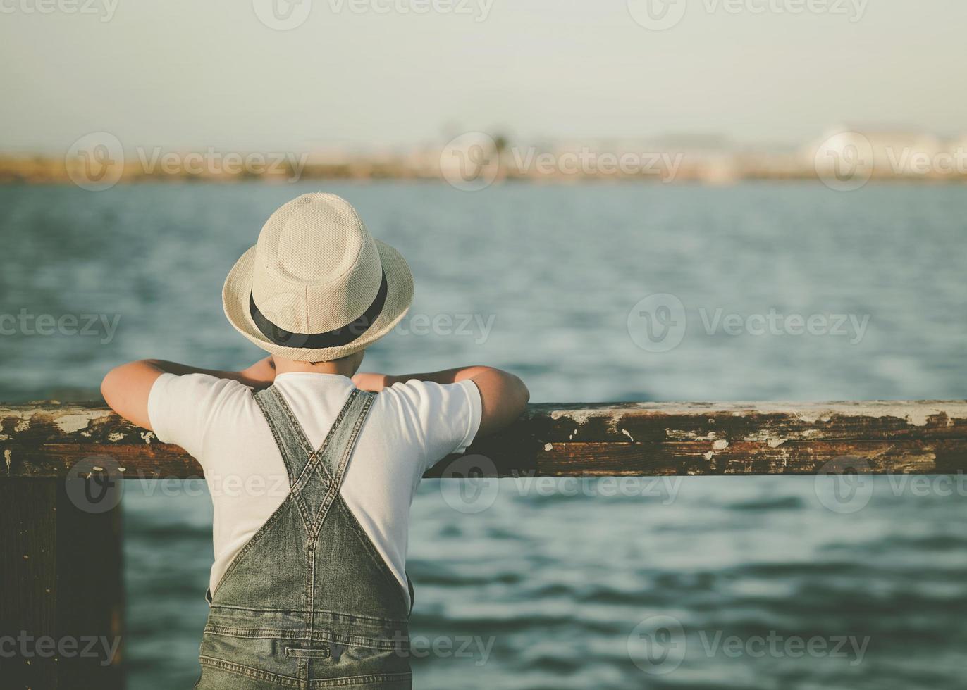 Back view of a Pensive child looking at the sea outdoor photo