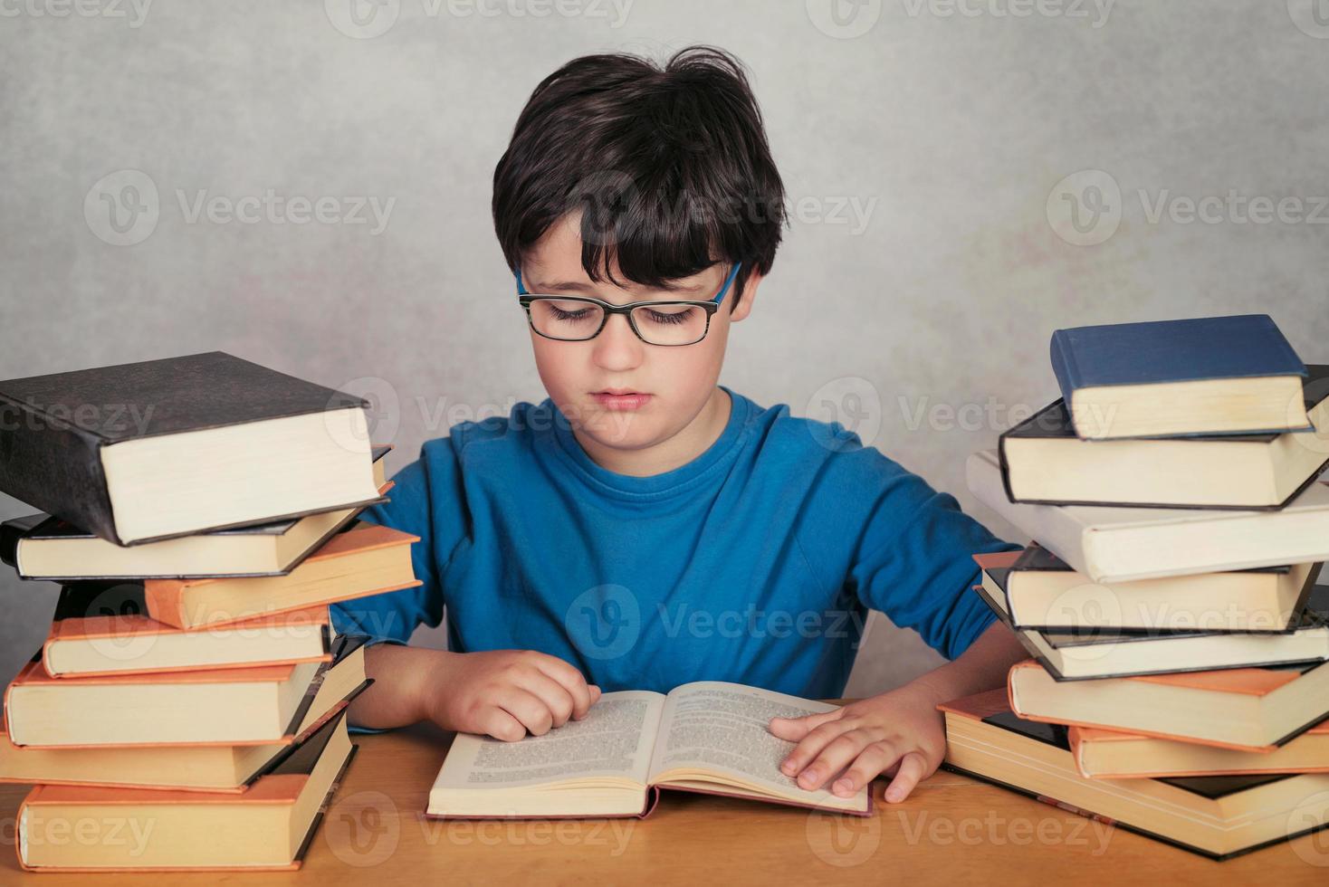 boy reading books on gray background photo