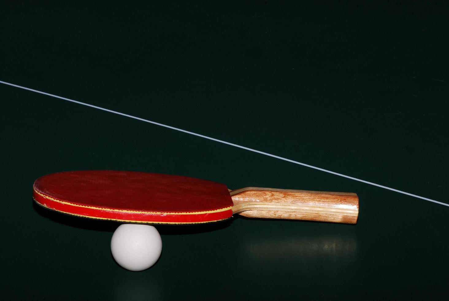 Pelota de raqueta de tenis de mesa y red en primer plano de la mesa de tenis de mesa foto