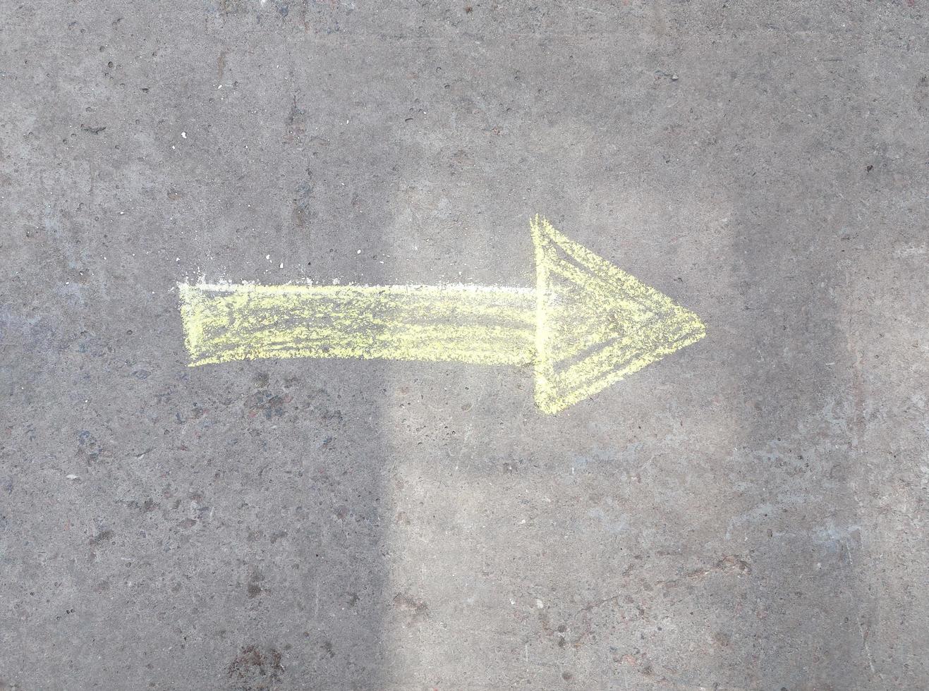 the arrow is drawn in chalk on the asphalt. indicates the direction. photo