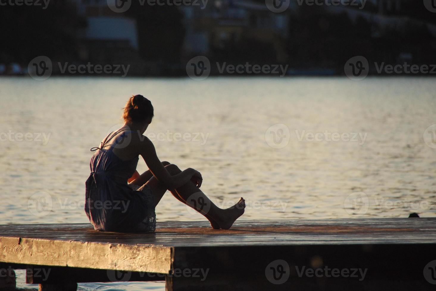 woman sitting in the summer at the lake photo