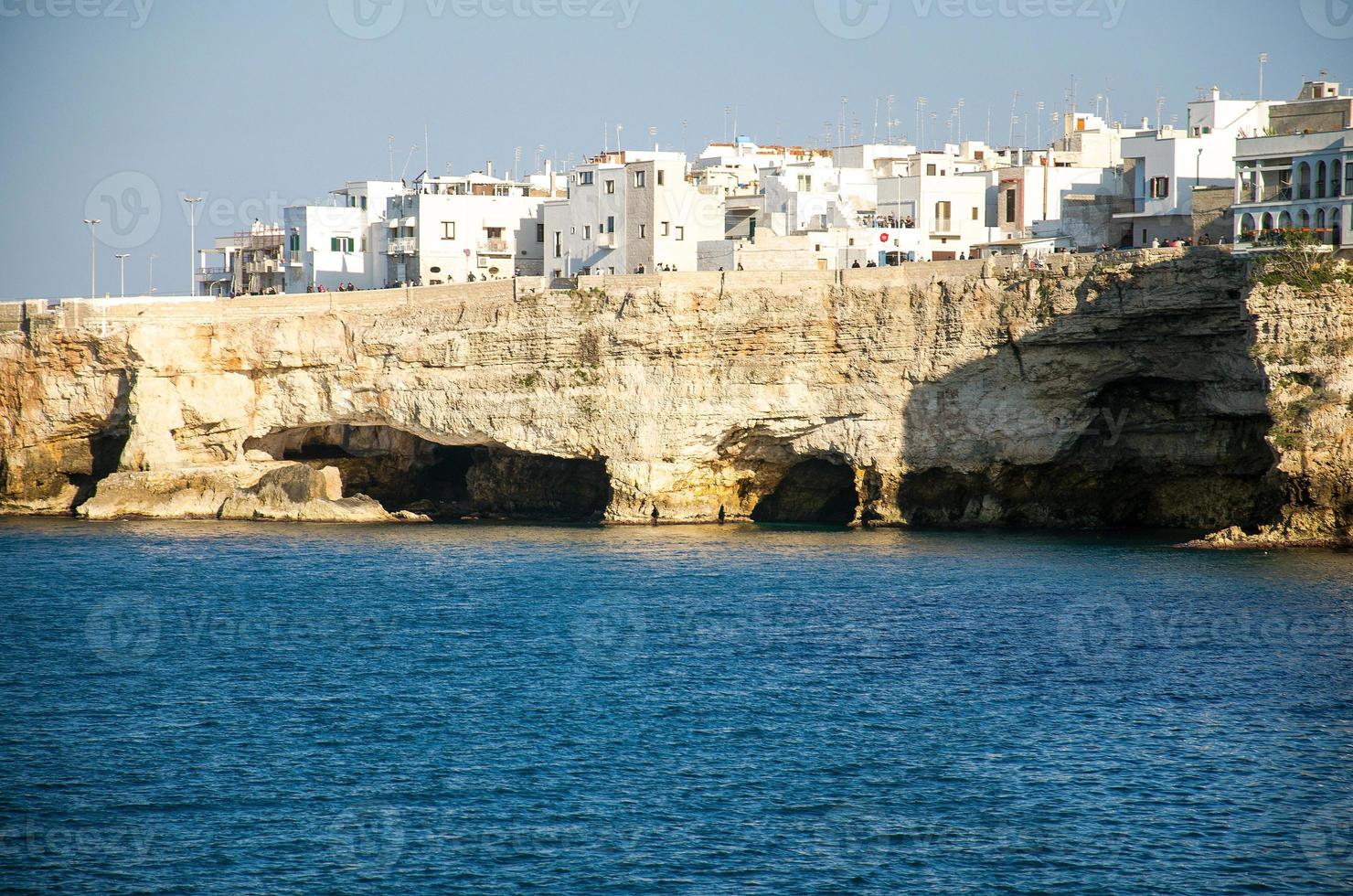 edificios blancos en grutas y acantilados en la ciudad de polignano a mare en puglia foto