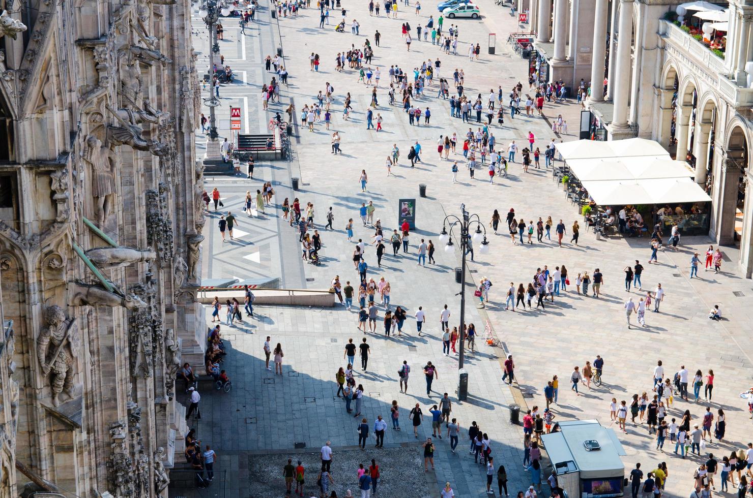 milán, italia multitud de pequeñas figuras muchas personas caminan en la piazza del duomo foto