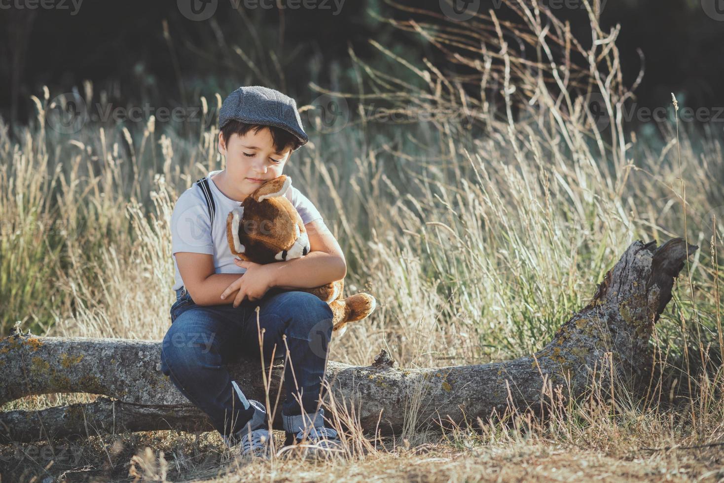 niño abrazando a su oso de peluche foto