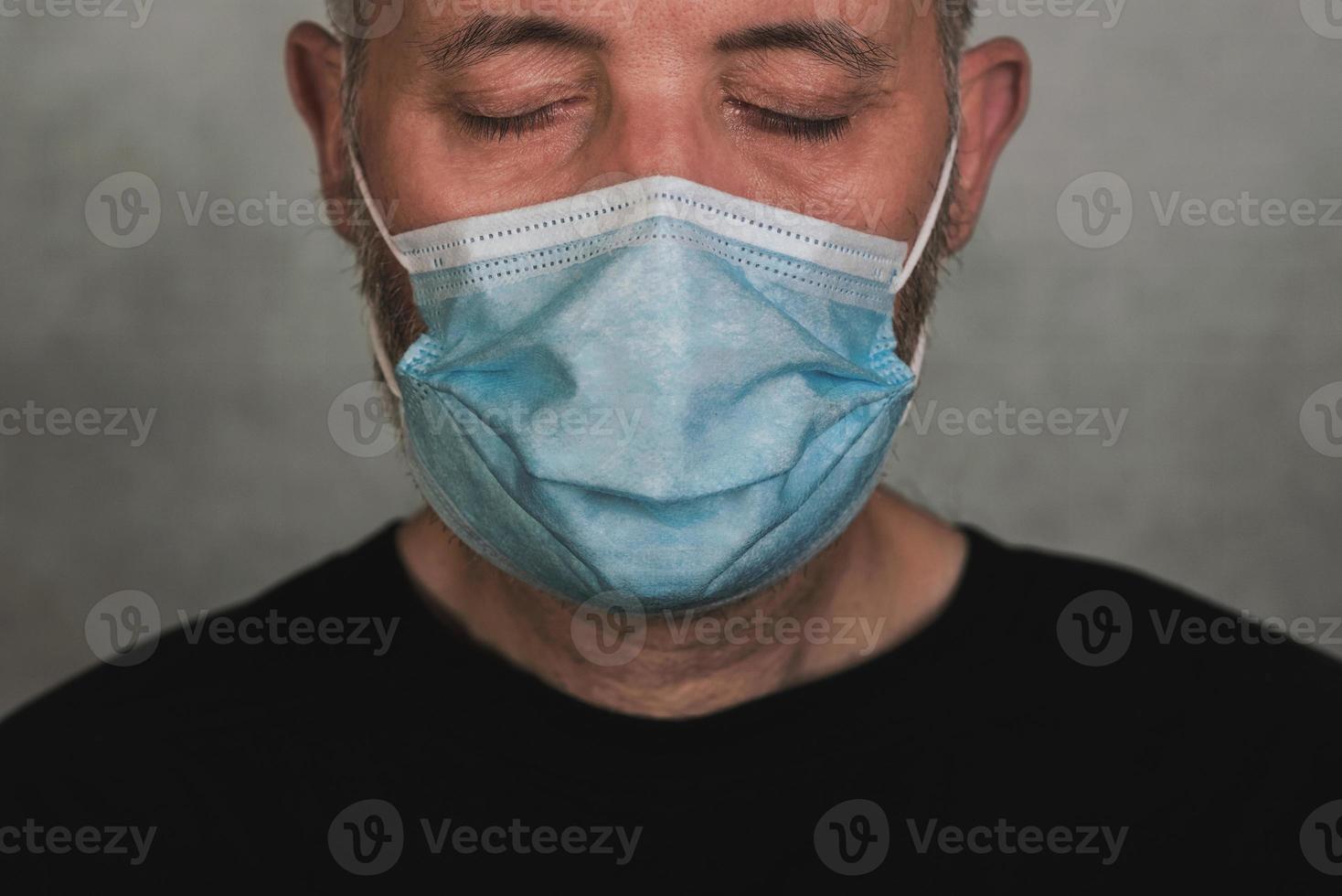 coronavirus, primer plano del hombre con máscara médica con los ojos cerrados foto