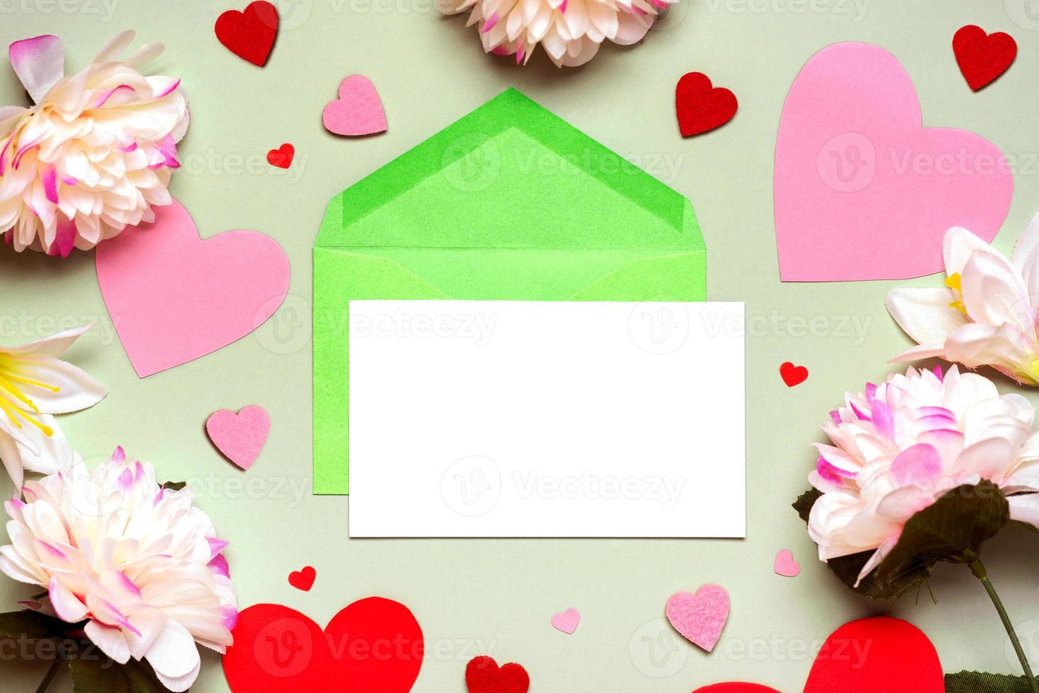 Greeting card. Green envelope and white paper with copy space, flowers and hearts. Congratulations on mother's day,birthday and Valentine's day photo