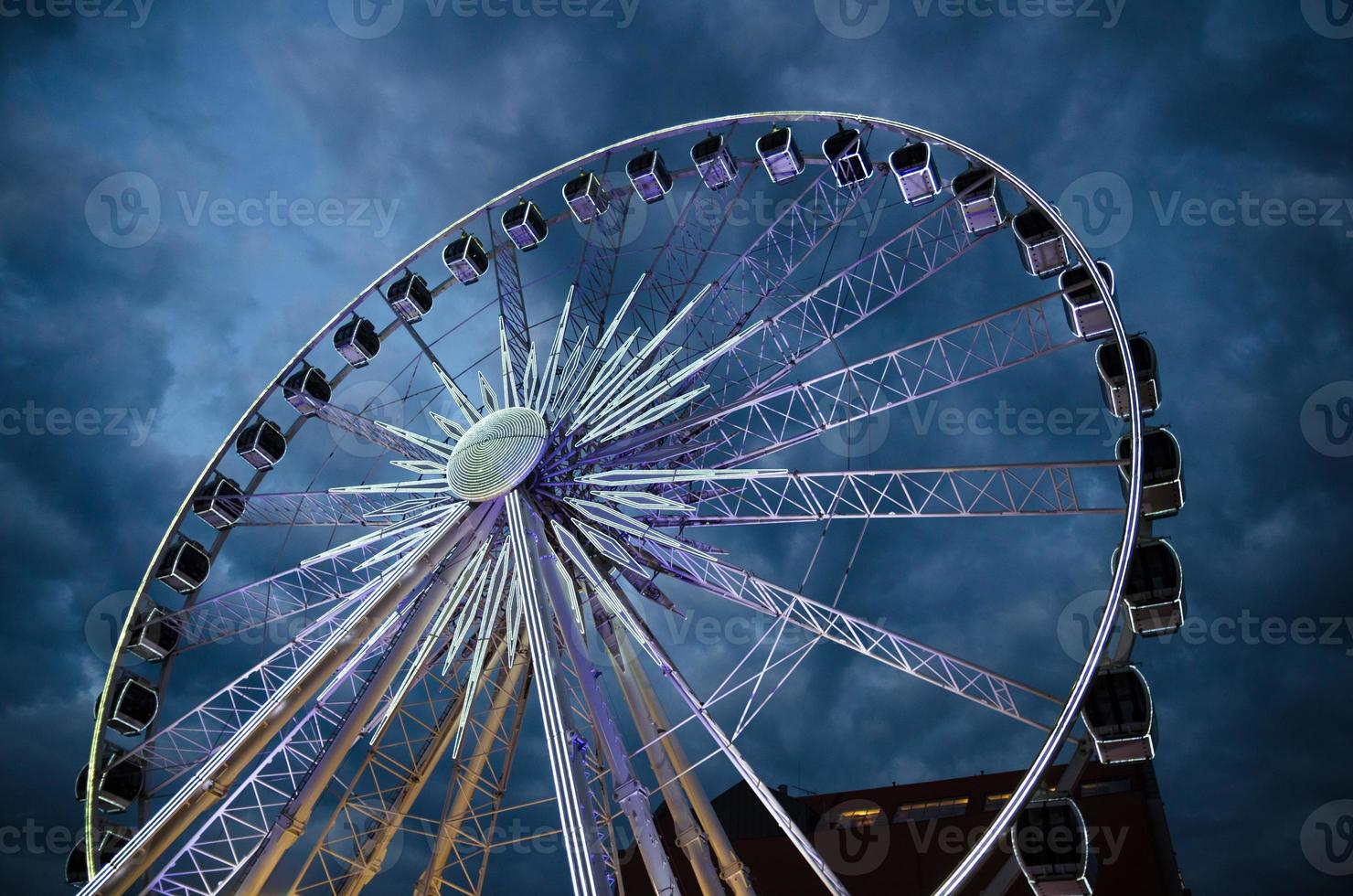 Big luminous ferris wheel in front of dark blue dramatic sky photo