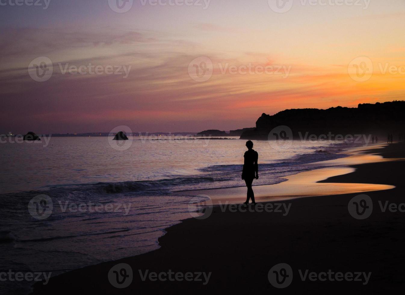 Portugal, Algarve, The best beaches of Portimao, Praia da Rocha, lilac golden sunset over the waves of The Atlantic Ocean photo
