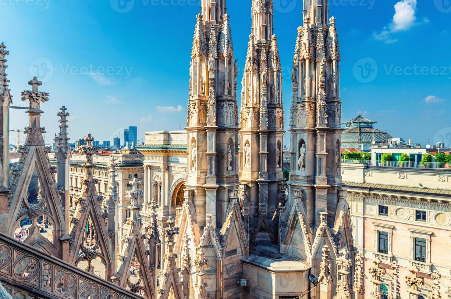 White marble statues on roof of famous Duomo di Milano Cathedral and top aerial view of Milan city centre photo