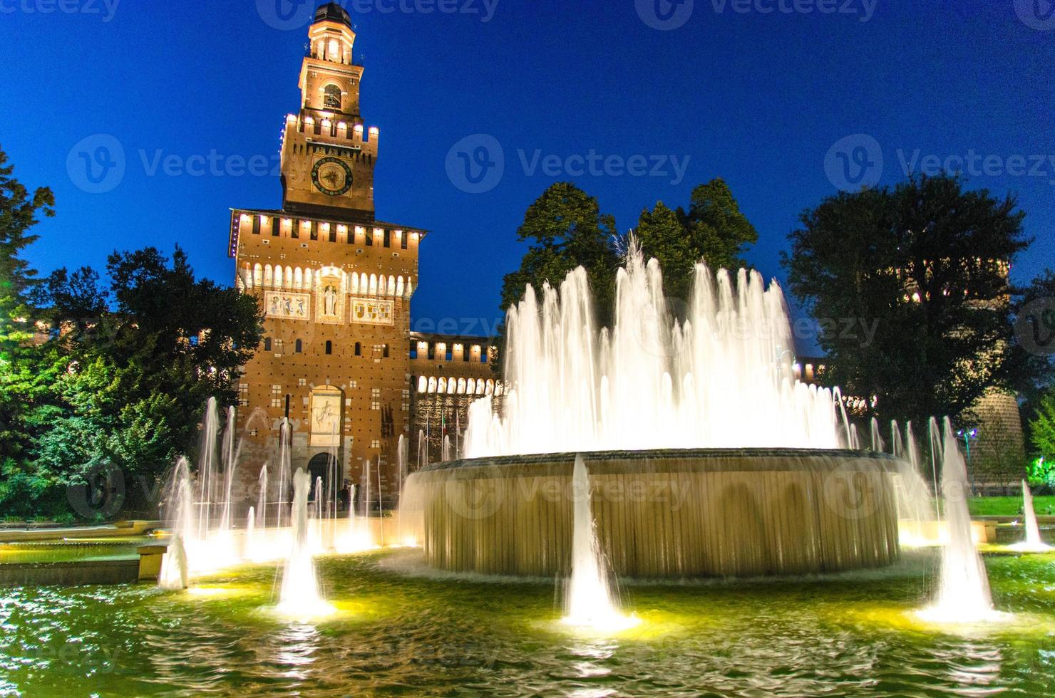 Old medieval Sforza Castle Castello Sforzesco facade, walls and tower La torre del Filarete with lights, trees photo