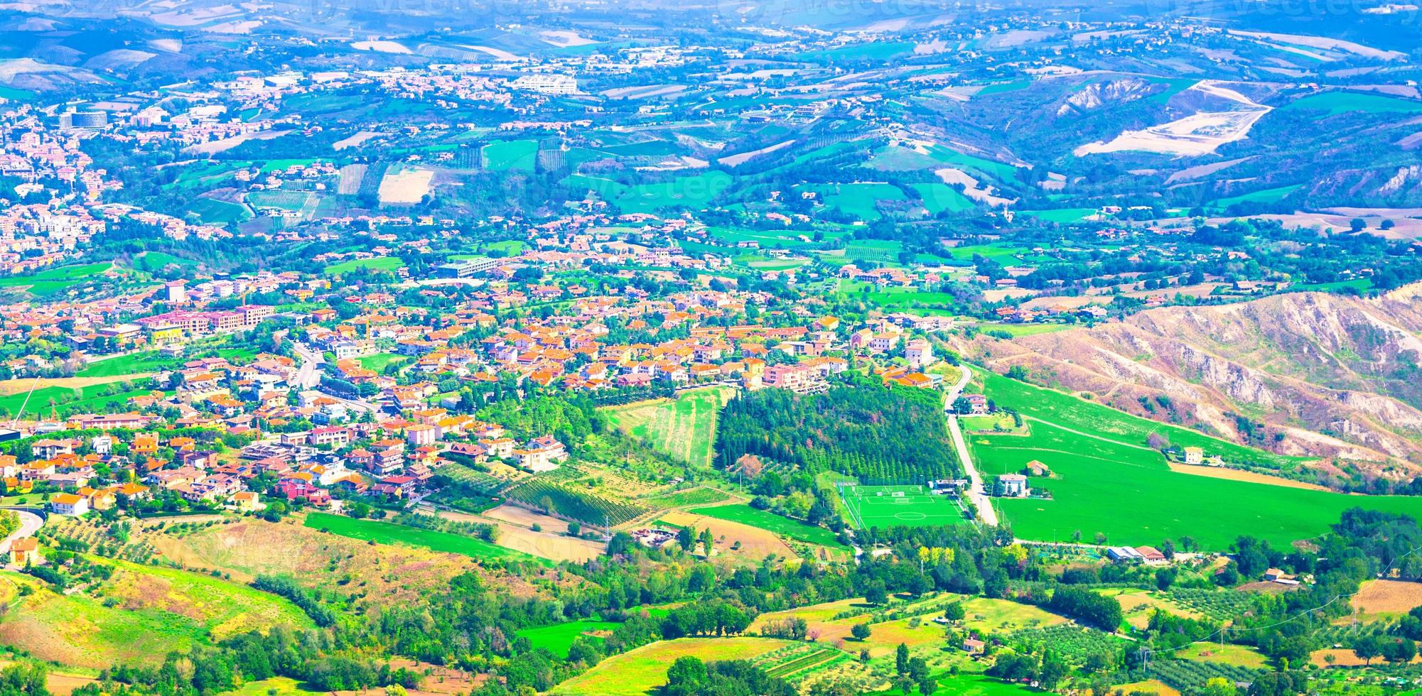 Aerial top panoramic view of landscape with valley, green hills, fields and villages of Republic San Marino photo