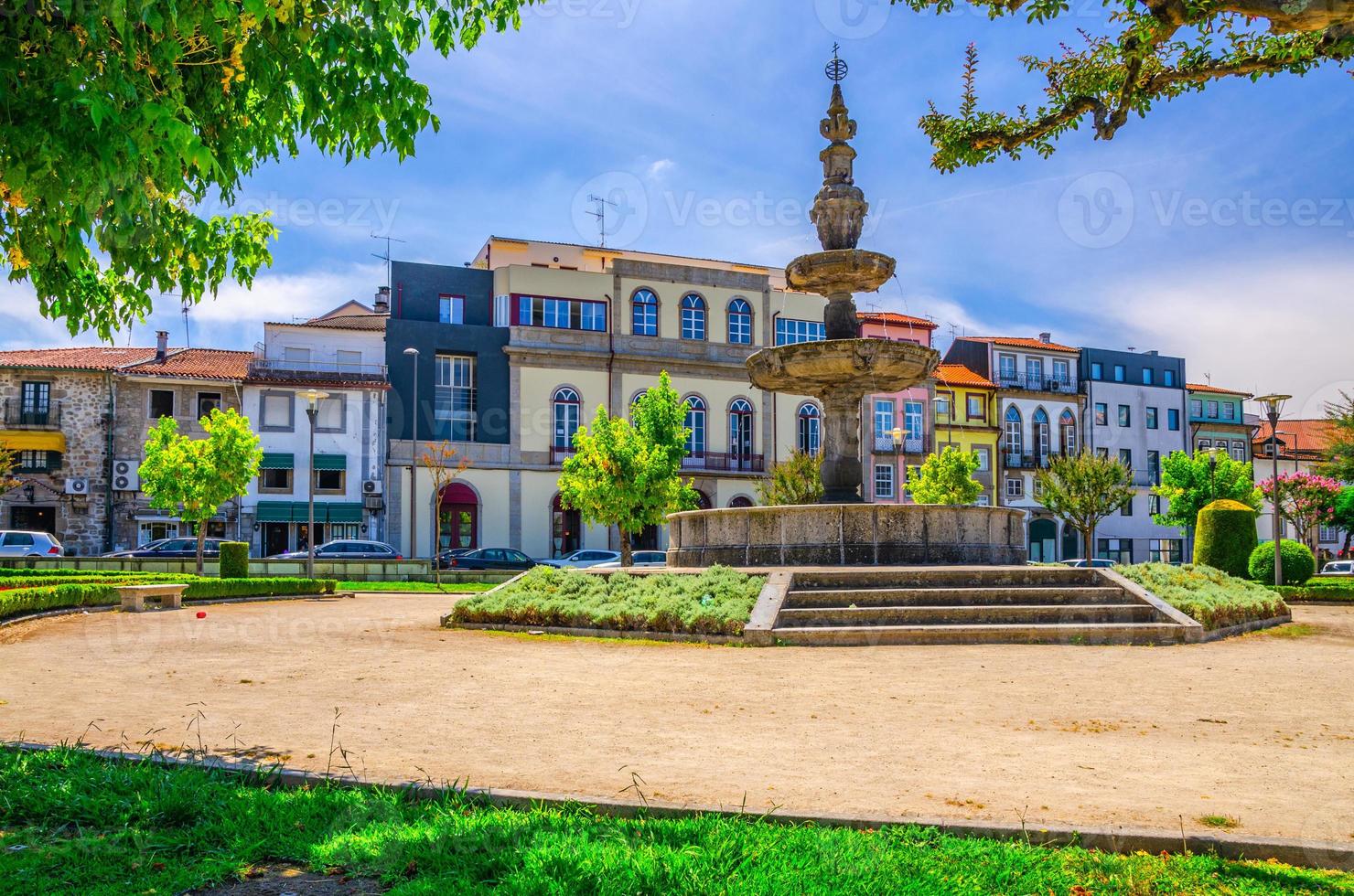 Fountain in small park and typical colorful buildings houses on Campo das Hortas square in Braga city photo