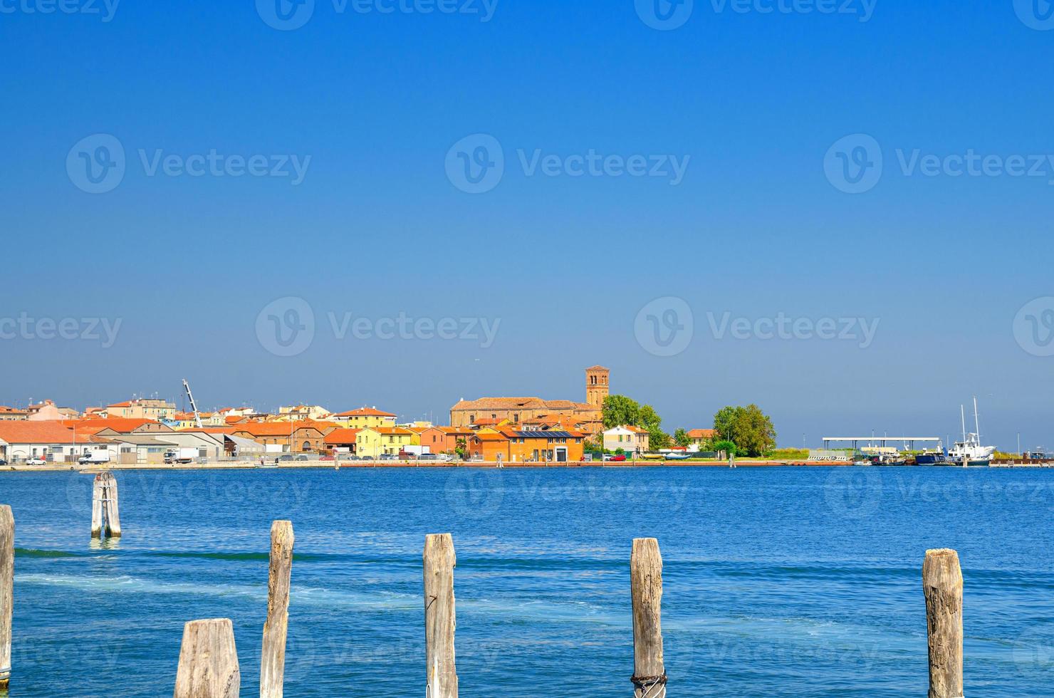 vista panorámica de la laguna de lusenzo con postes de madera en el agua y la ciudad de chioggia foto