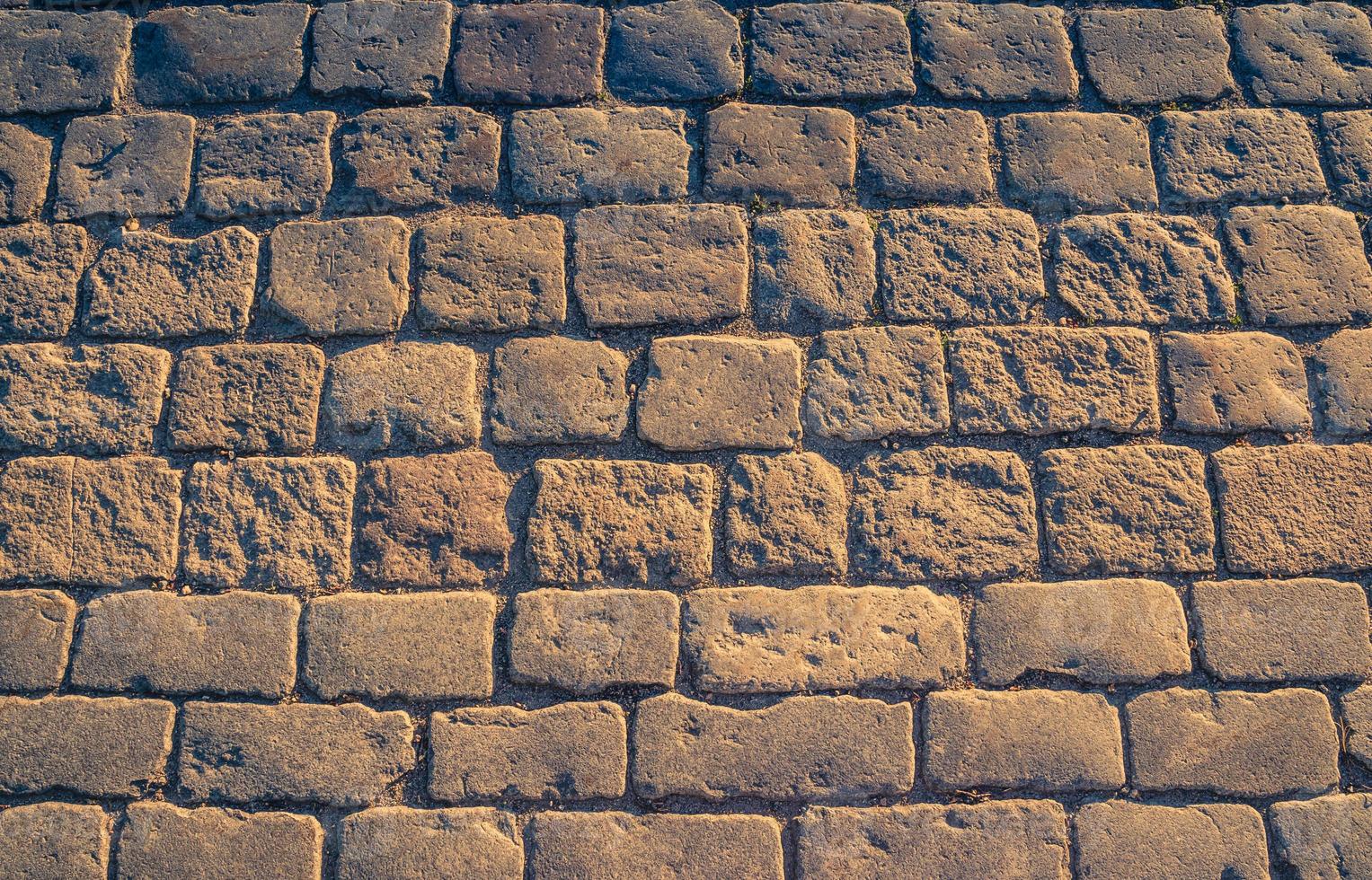 Cobblestone pavement background with copy space, close-up texture photo