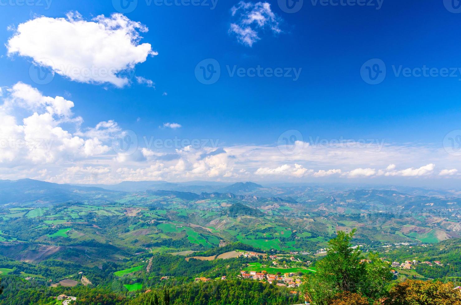 Aerial top panoramic view of landscape with valley, green hills, fields and villages of Republic San Marino photo