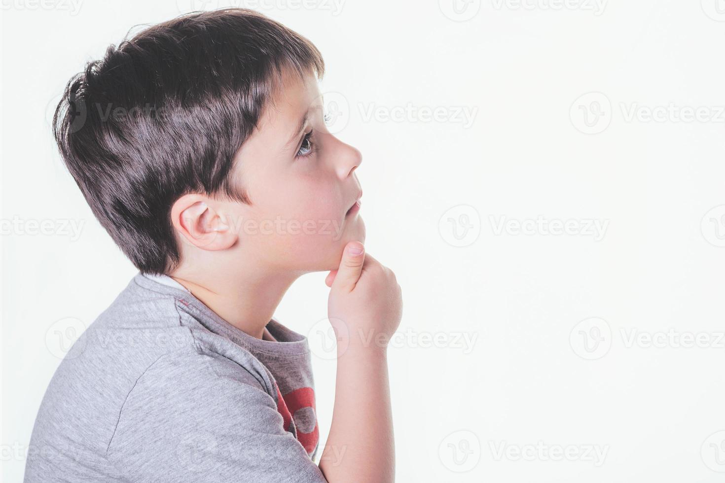 thoughtful child on a white wall photo