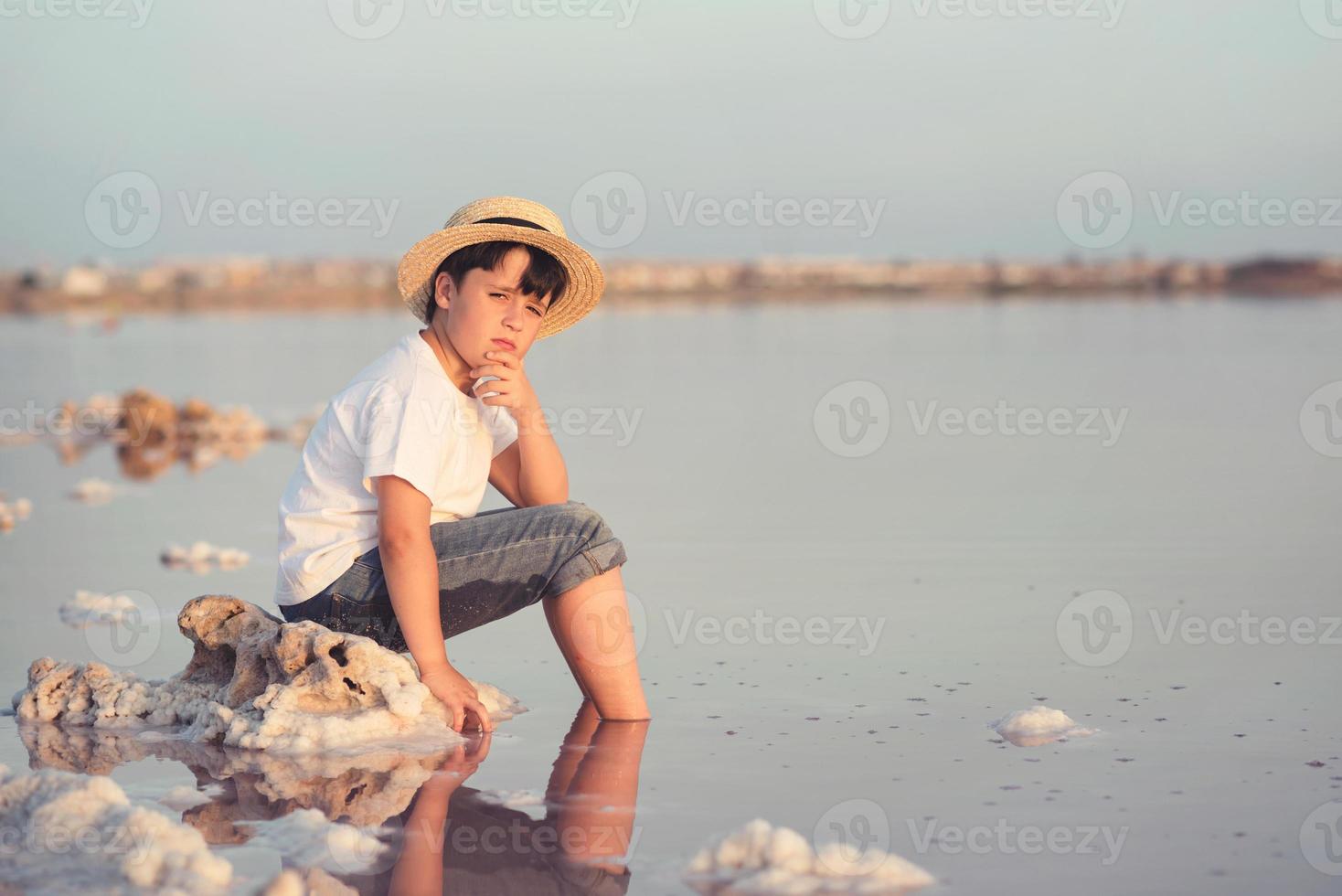 niño triste y pensativo en la playa foto