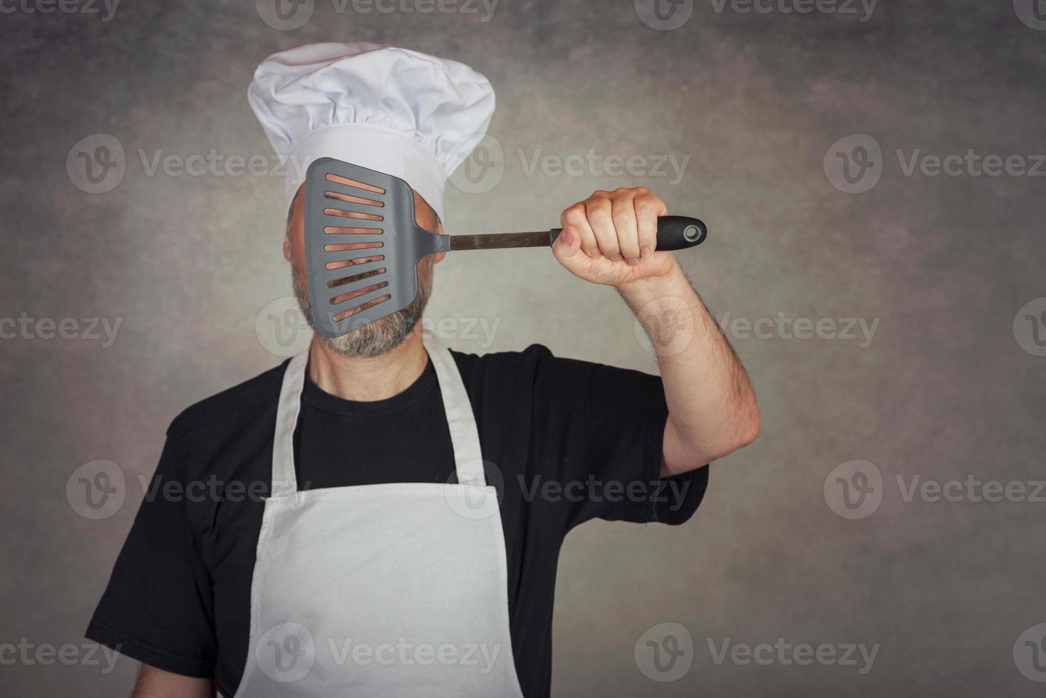 man holding spatula in his eyes photo