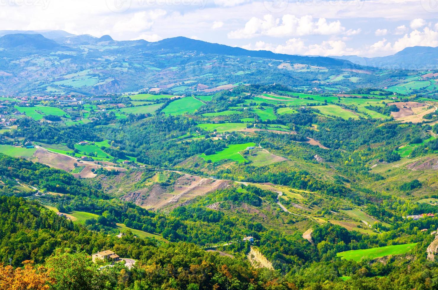 Aerial top panoramic view of landscape with valley, green hills, fields and villages of Republic San Marino photo