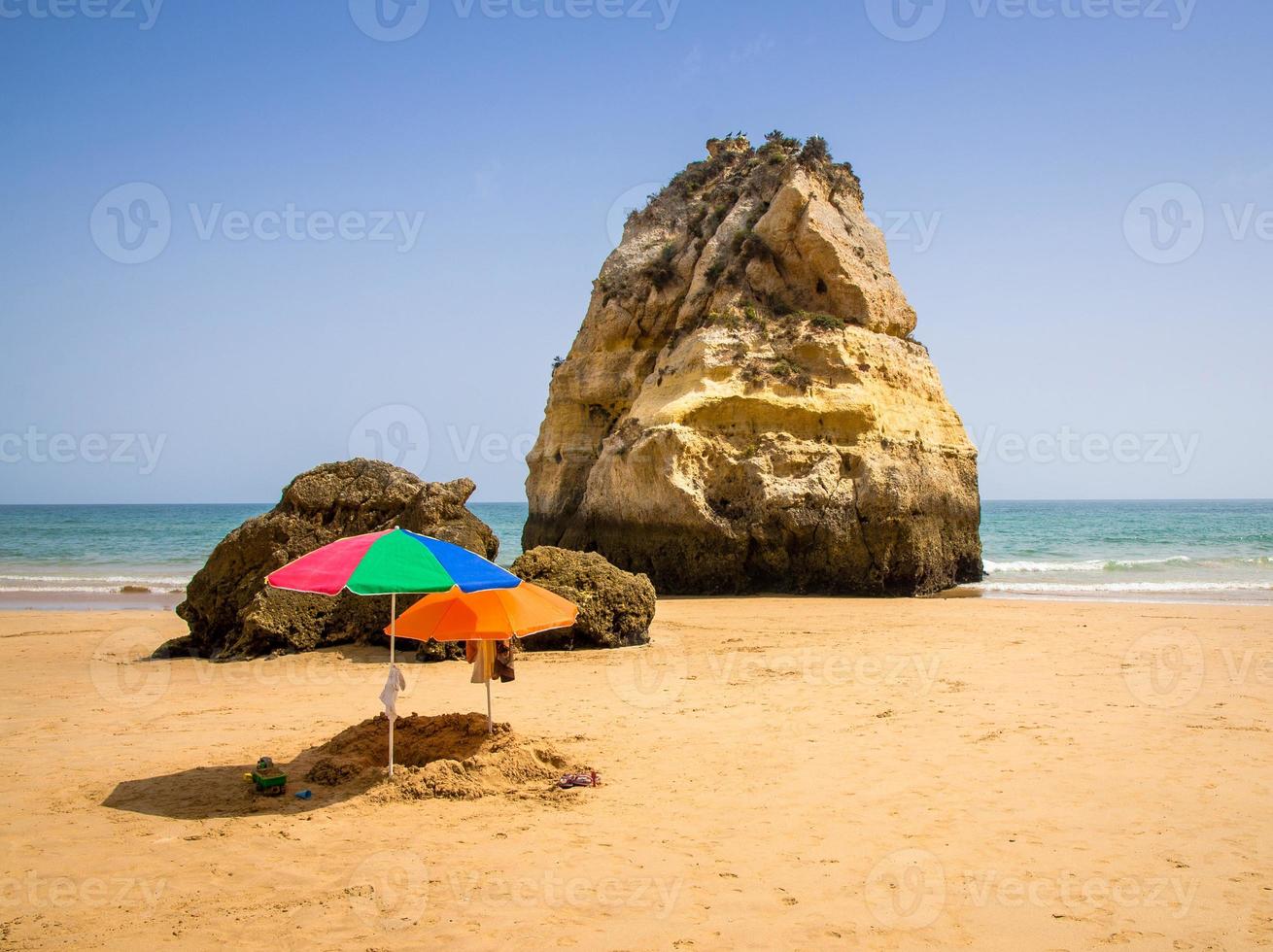 Portugal, Algarve, two colored sun umbrellas on the beach, children's sandbox on the beach photo