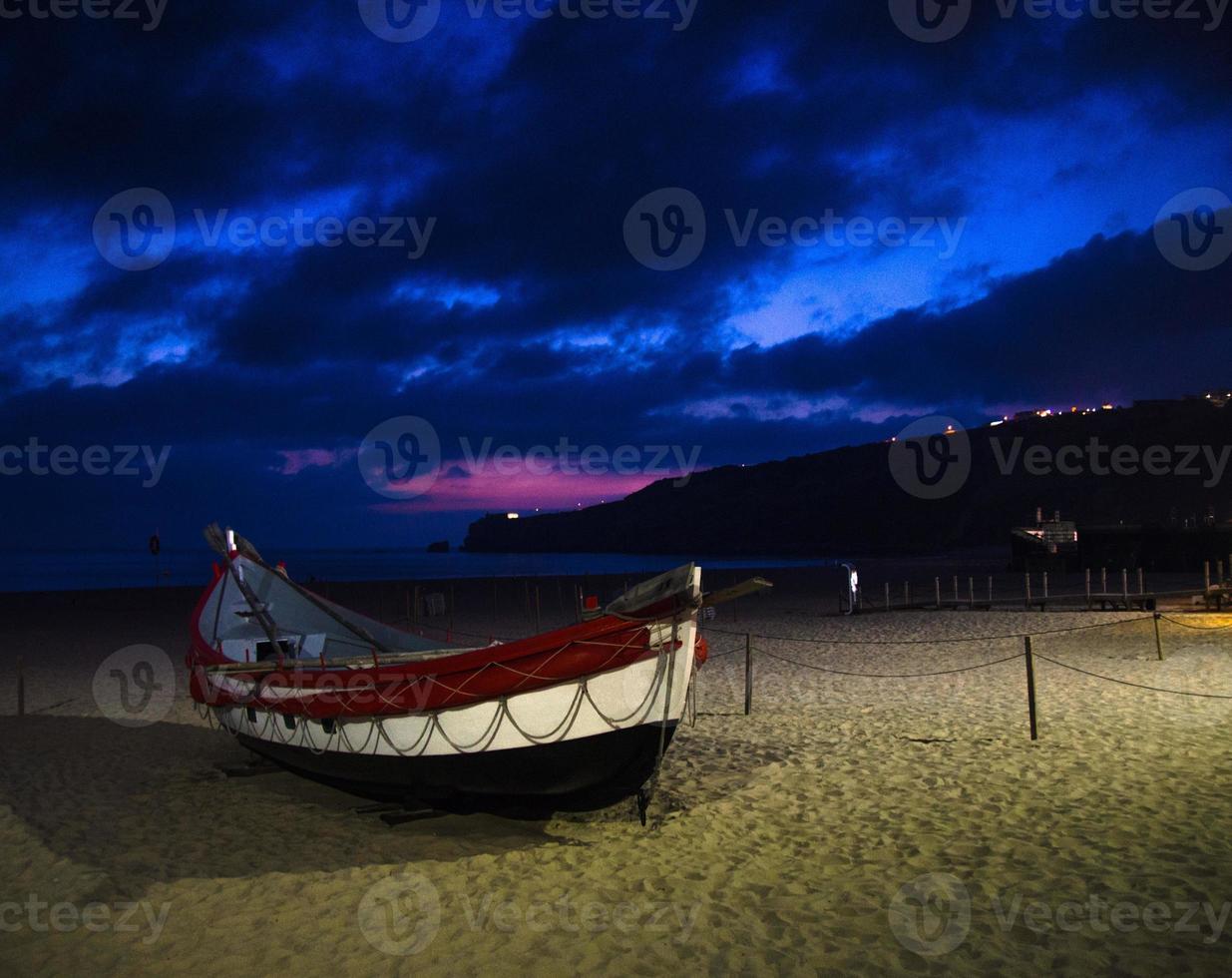 Portugal, Nazare beach, colored wooden boats, panoramic view of Nazare Town, Traditional Portuguese fishing boats photo