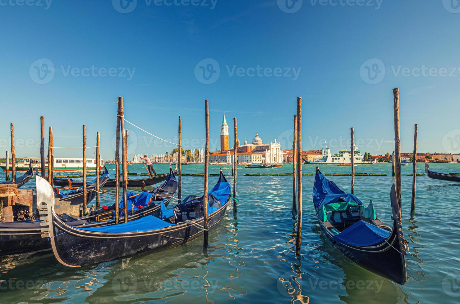 Gondolas moored docked on water in Venice. Gondoliers sailing San Marco basin photo