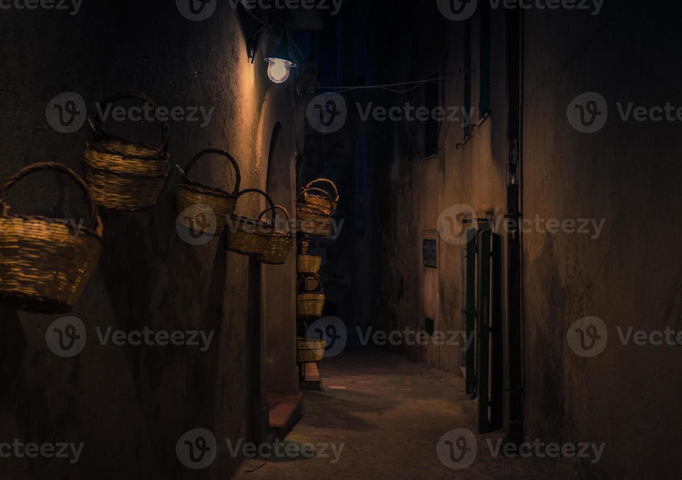 Evening street with bright lanterns baskets on wall, Tropea, Italy photo