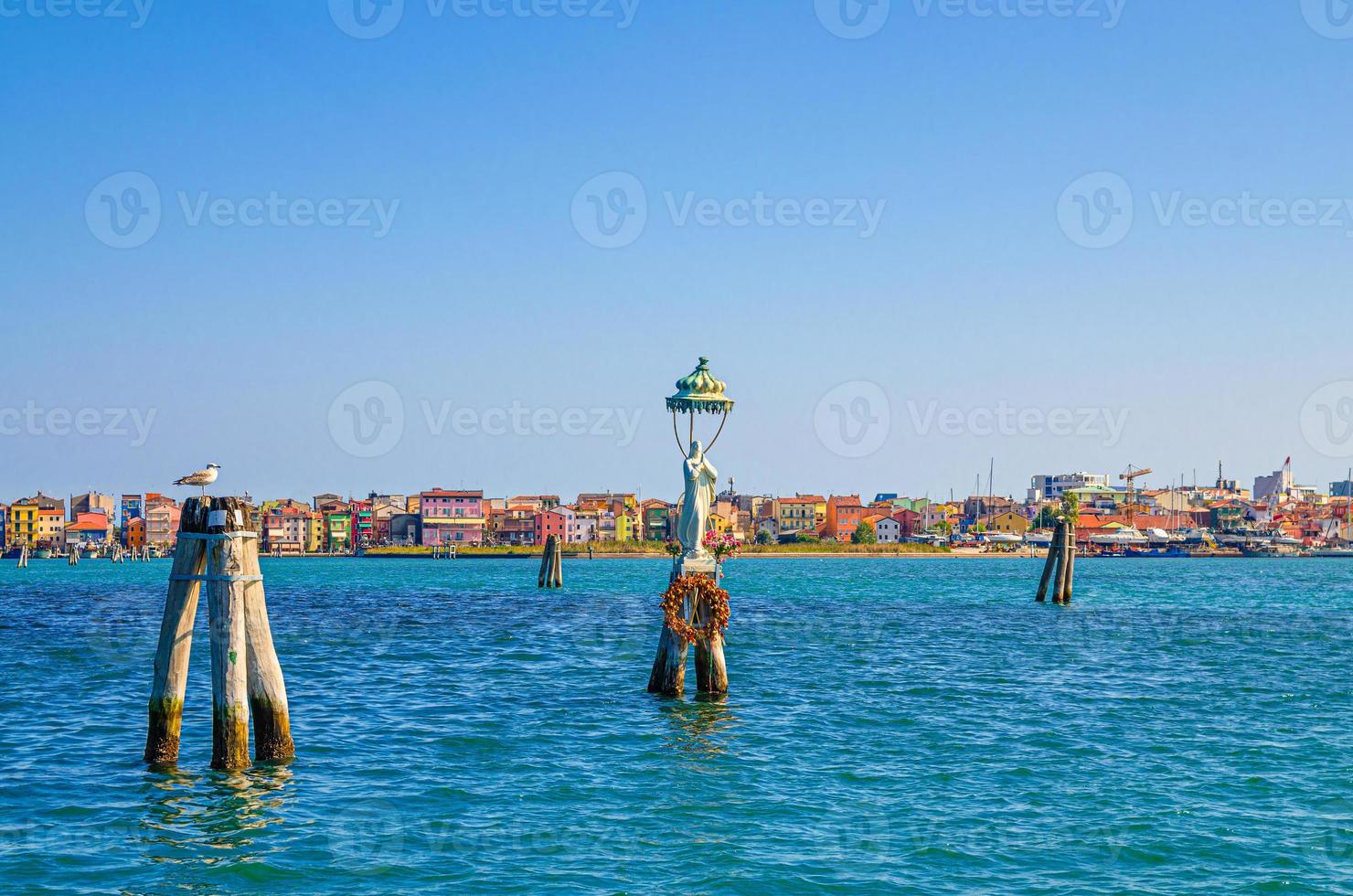 Panoramic view of Lusenzo lagoon with wooden bricole poles in water and Sottomarina town photo