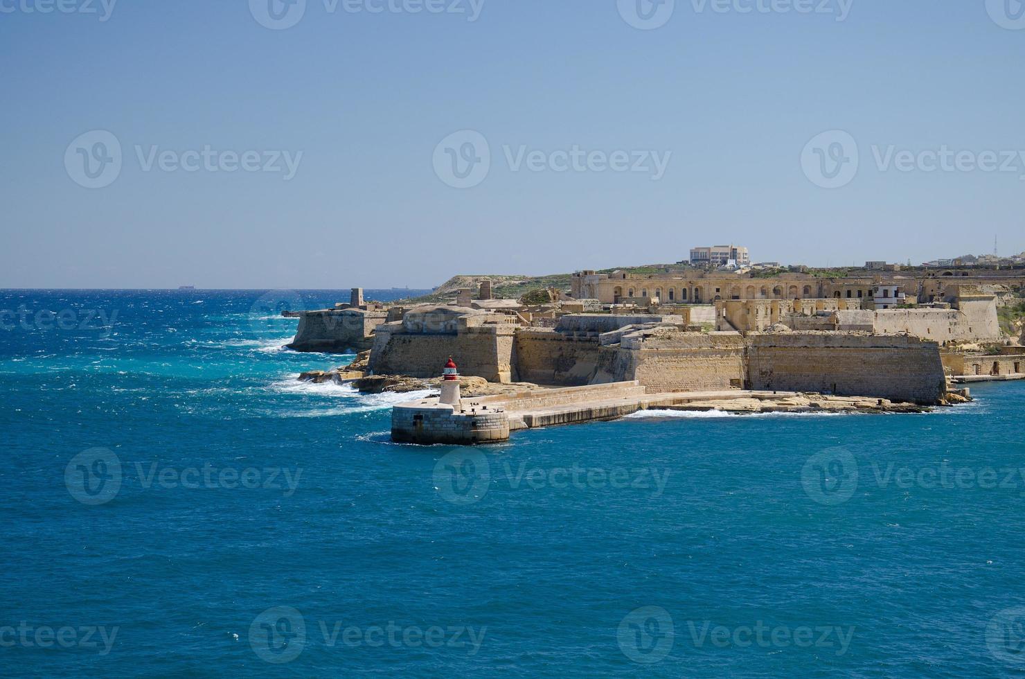 vista de la entrada del puerto con faro, valletta, malta foto